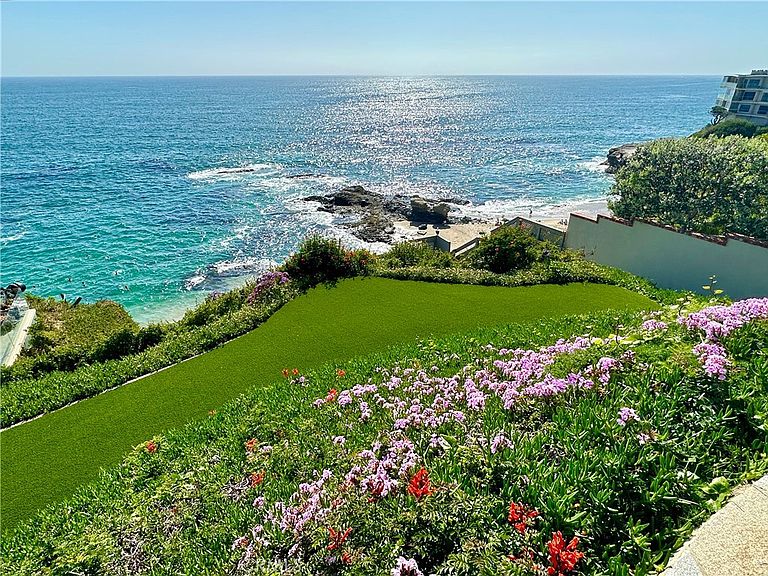 Lawn and flowering garden meeting the bluff above the surf