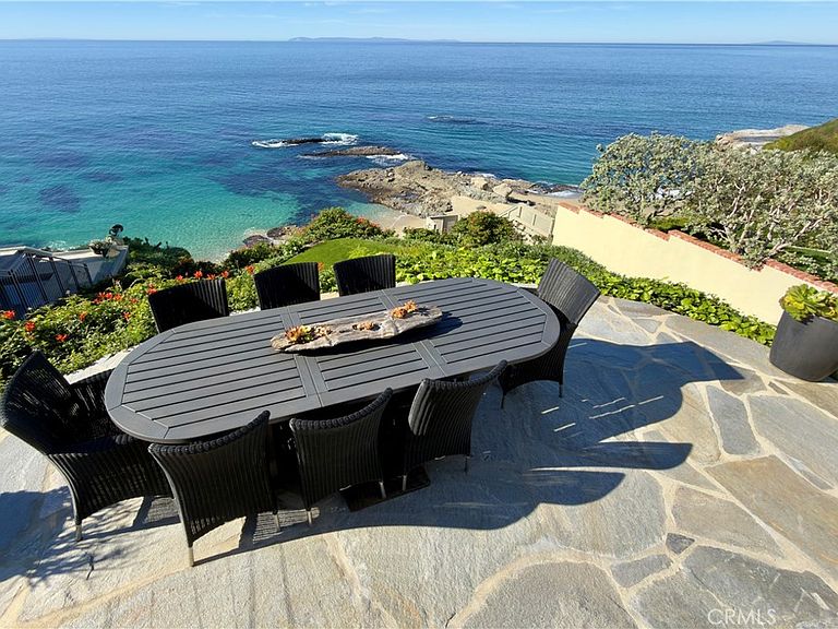 Outdoor dining table with fire feature, ocean panorama and rock formations